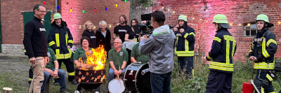 Lagerfeuerszene mit Spielmannszug, Feuerwehr und Metal-Bus